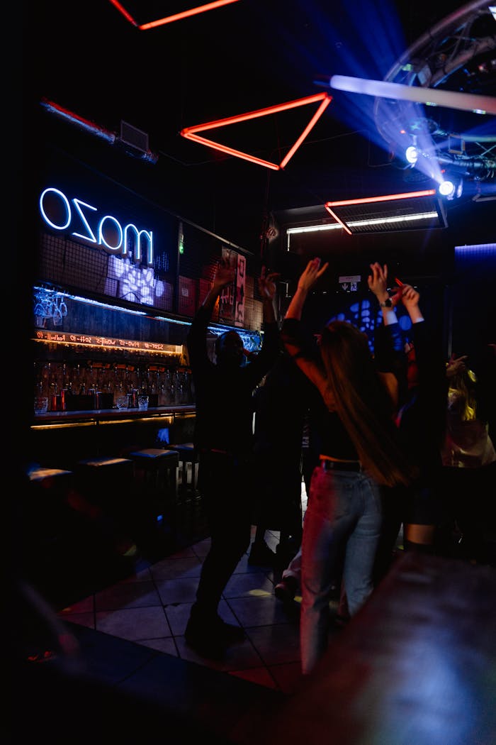 about-bg Vibrant nightclub with people dancing under neon lights, perfect for nightlife themes.